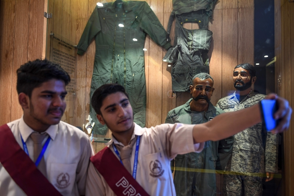 Students look at a part of an Indian Mig-21 fighter aircraft which was being flown by  Indian pilot Wing Commander Abhinandan Varthaman whose plane was shot down over Kashmir earlier this year, put on display at Pakistan Air Force Museum in Karachi, on Tuesday. — AFP