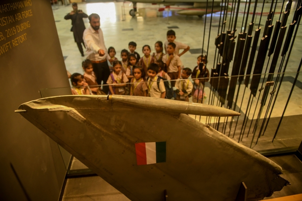 Students look at a part of an Indian Mig-21 fighter aircraft which was being flown by  Indian pilot Wing Commander Abhinandan Varthaman whose plane was shot down over Kashmir earlier this year, put on display at Pakistan Air Force Museum in Karachi, on Tuesday. — AFP