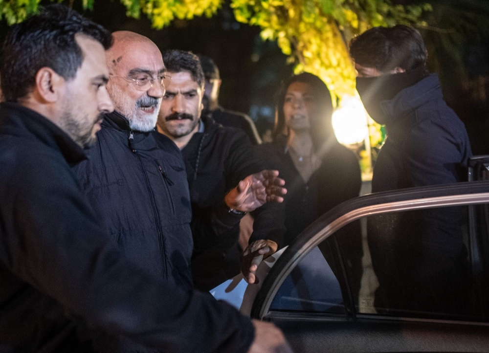 Journalist and writer Ahmet Altan, center, walks with Turkish police as his daughter Senem Altan, right, tries to say him goodbye as he is detained on Tuesday, at Kadikoy neighborhood in Istanbul. — AFP