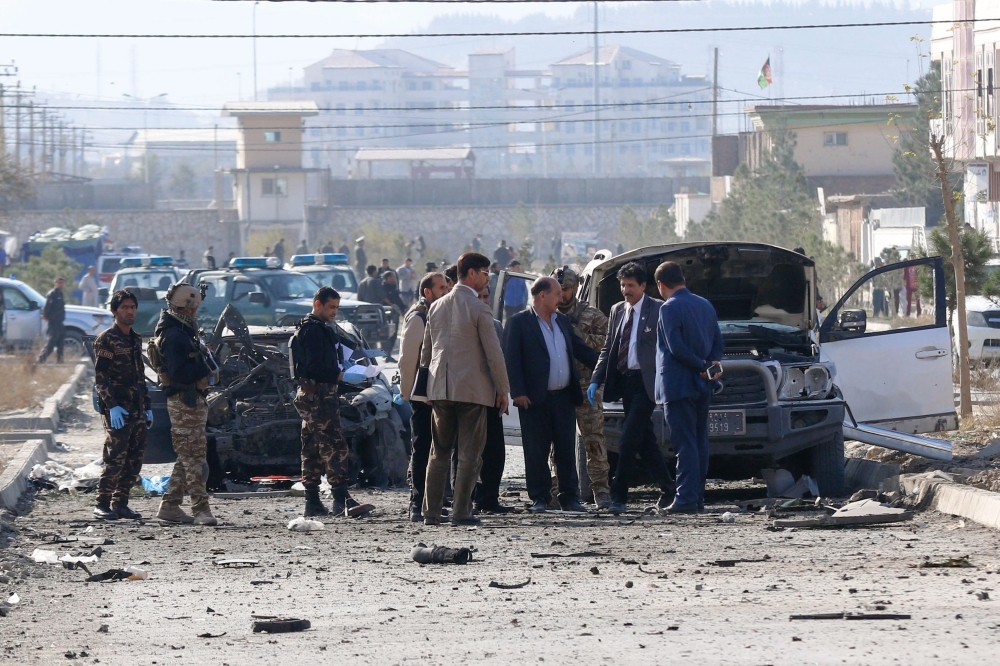 Security personnel and investigators gather at the site of a suicide attack in Kabul on Wednesday. — AFP