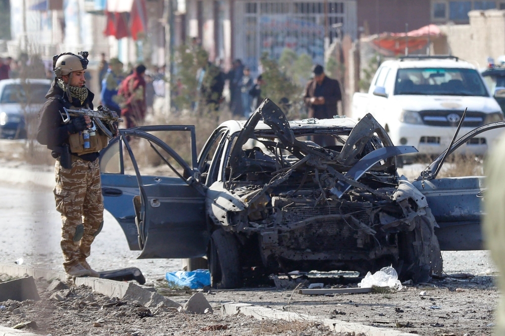 Security personnel and investigators gather at the site of a suicide attack in Kabul on Wednesday. — AFP