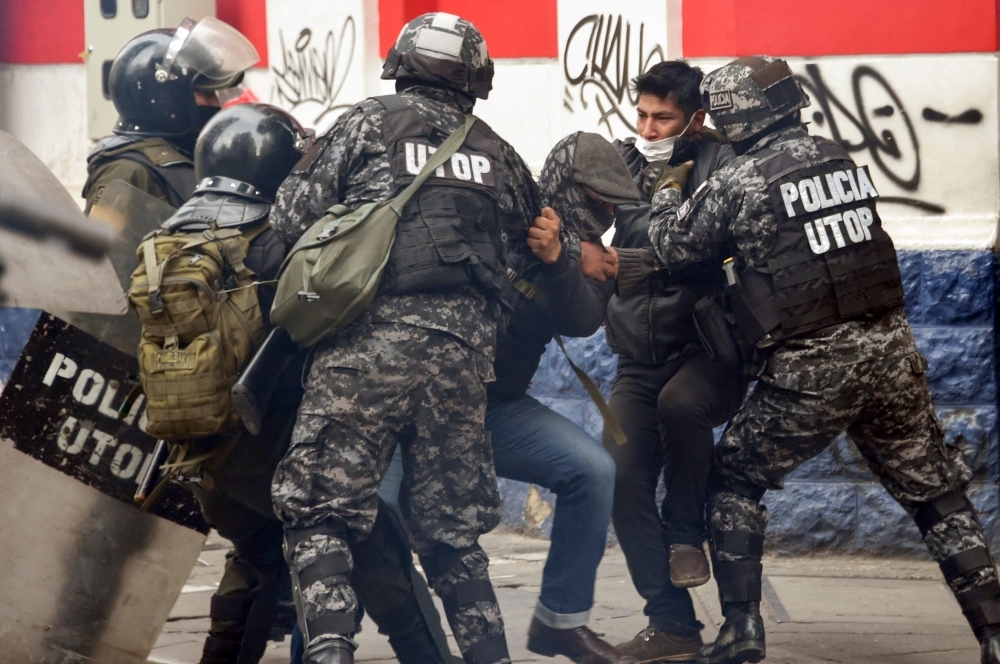 Men are detained by Police Operations Tactical Unit (UTOP) as clashes erupted with supporters of Bolivian ex-President Evo Morales and locals discontented with the political situation during a protest in La Paz on Wednesday. — AFP