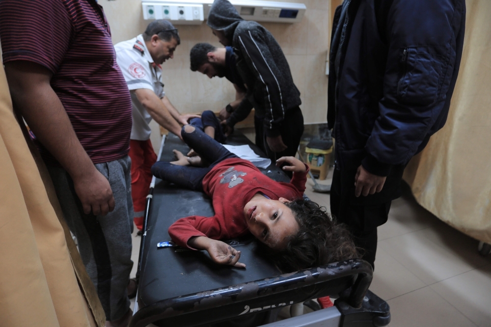 Palestinian medical workers tend to wounded children, members of a family where six were killed in an Israeli air strike, in central Gaza Strip's Deir Al-Balah on Thursday. — AFP