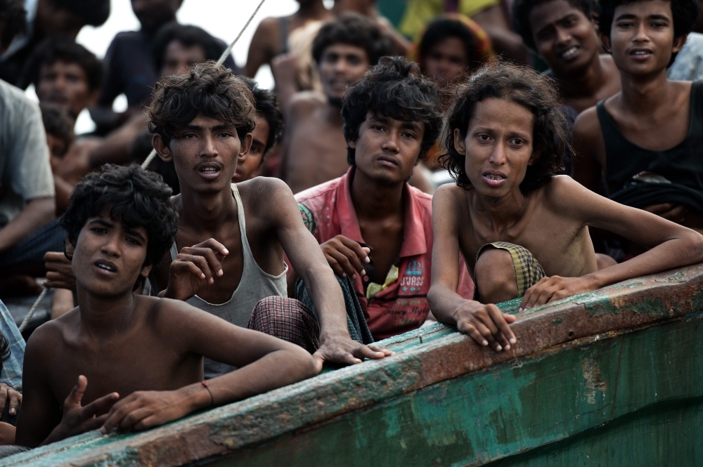 Rohingya refugees carry a woman over a shallow canal after crossing the Naf River as they flee violence in Myanmar to reach Bangladesh in Palongkhali near Ukhia in this Oct. 16, 2017 file photo. — AFP