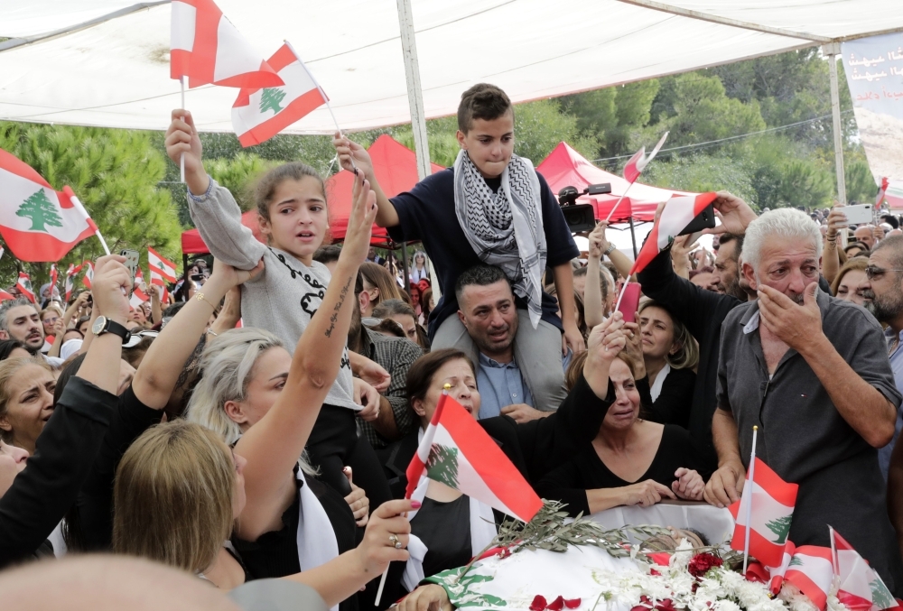 The coffin of slain Lebanese protester Alaa Abu Fakhr, draped in a national flag, is carried  by mourners through the streets of his hometown of Chouaifet, southeast of Beirut, during his funeral procession on Thursday. — AFP