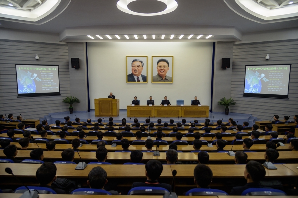 In a photo taken on Nov. 12, 2019 North Korean scientists sit before the portraits of late North Korean leaders Kim Il Sung and Kim Jong Il as they attend a symposium on 'Space Science and Technology 2019' at the Sci-tech Complex in Pyongyang. — AFP