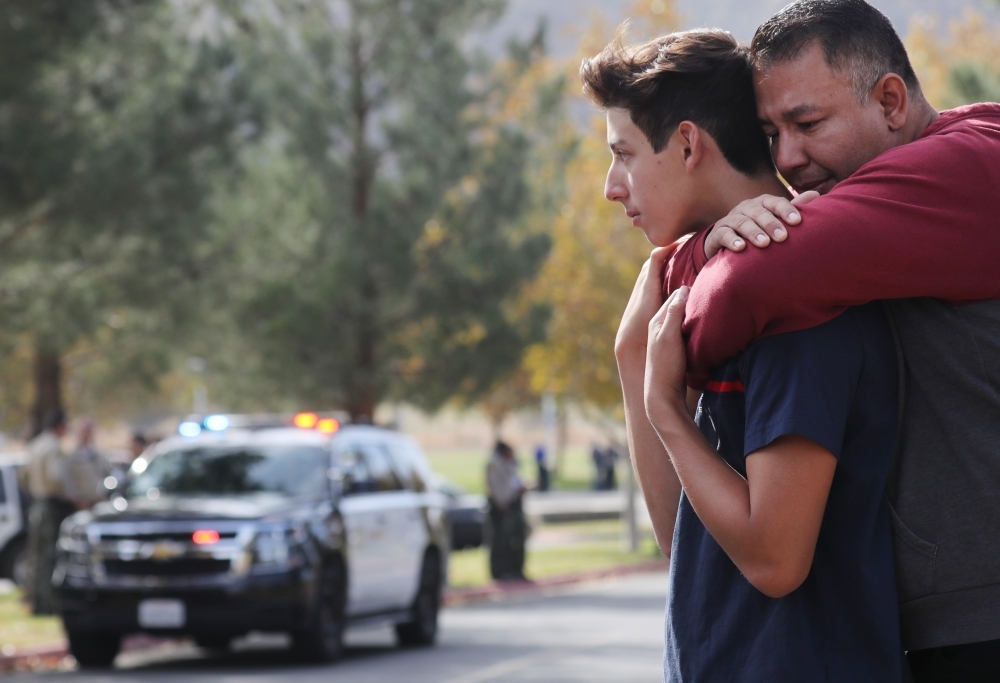 Students and parents embrace after being picked up at Central Park, after a shooting at Saugus High School in Santa Clarita, California on Thursday. — AFP