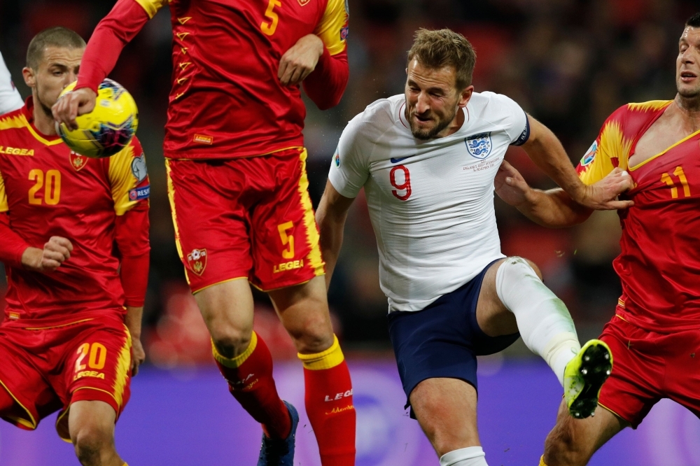 England's striker Harry Kane (C) heads home their second goal during the UEFA Euro 2020 qualifying first round Group A football match between England and Montenegro at Wembley Stadium in London on Thursday. — AFP
