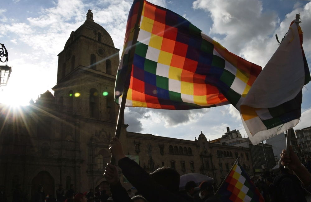 A demonstrator waves a Wiphala flag during a protest against the interim government in La Paz on Friday. -AFP