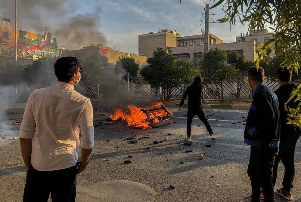 Iranian protesters gather around a fire during a demonstration against an increase in gasoline prices in the capital Tehran, on Saturday. One person was killed and others injured in protests across Iran, hours after a surprise decision to increase petrol prices. — AFP
