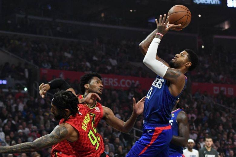 LA Clippers forward Paul George taking a shot over center Damian Jones and guard DeAndre' Bembry of the Atlanta Hawks on Sunday. — Courtesy photo