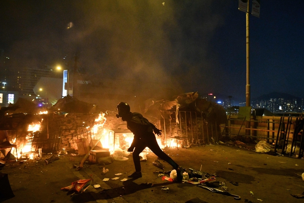 Protesters throw Molotov cocktails at the police who use water canon outside the Hong Kong Polytechnic University in Hong Kong on Sunday. -AFP