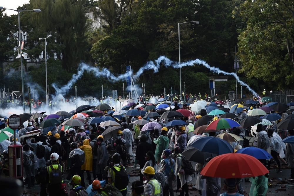 Protesters throw Molotov cocktails at the police who use water canon outside the Hong Kong Polytechnic University in Hong Kong on Sunday. -AFP