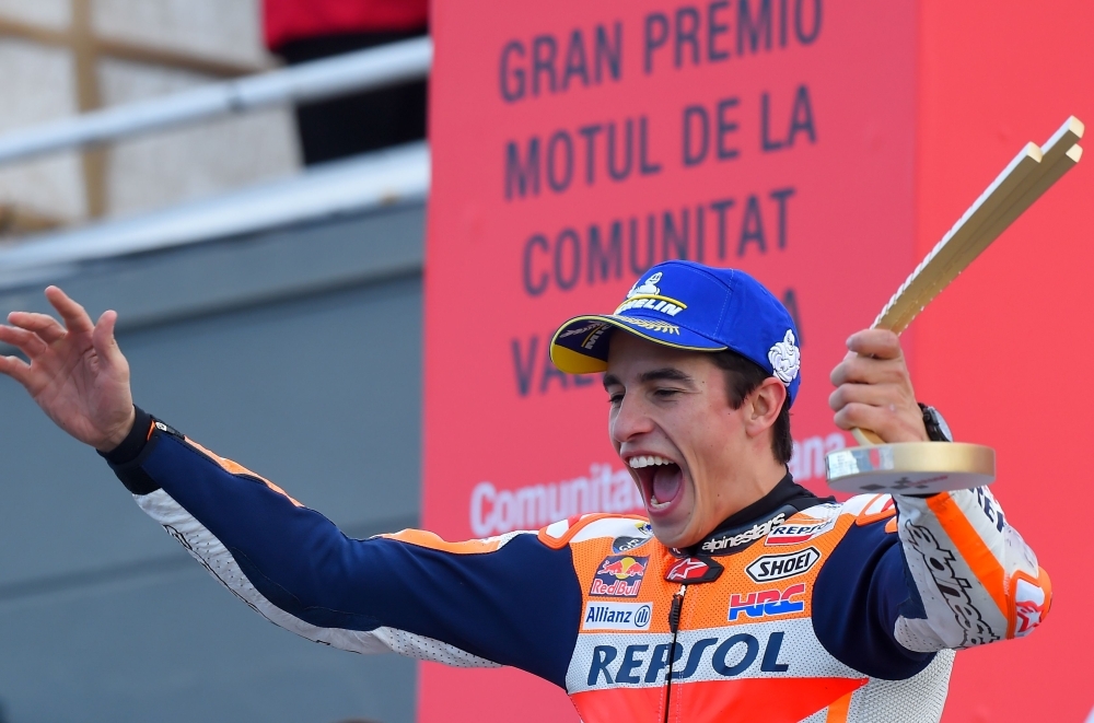 Repsol Honda Team's Spanish rider Marc Marquez celebrates with the trophy on the podium after winning the MotoGP race of the MotoGP Valencia Grand Prix at the Ricardo Tormo racetrack in Cheste near Valencia, on Sunday. World champion Marc Marquez clinched his 12th MotoGP victory of the season in final race in Valencia. — AFP