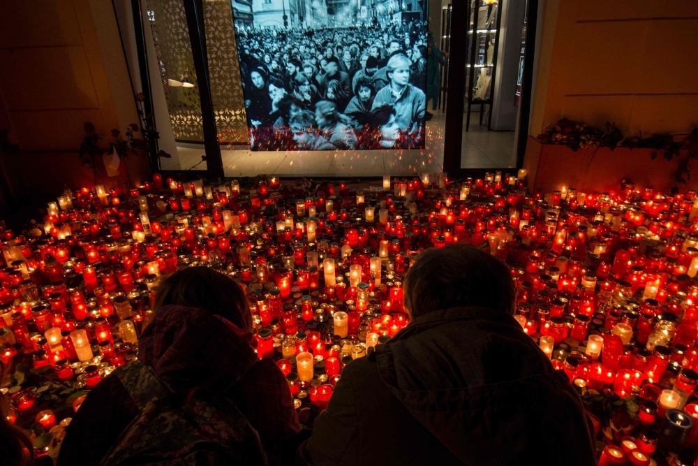  People place candles at a memorial to commemorate the 30th anniversary of the so-called Velvet Revolution on Sunday in Prague. -AFP 