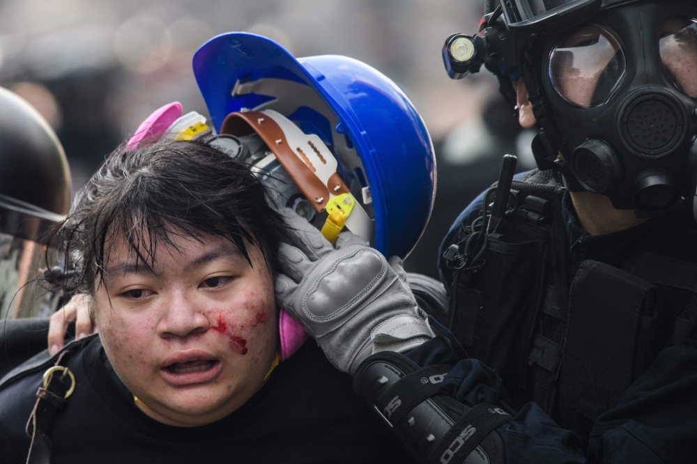  Police detain a protester during an attempt to escape the campus of the Hong Kong Polytechnic University in the Hung Hom district of Hong Kong on Monday. -AFP