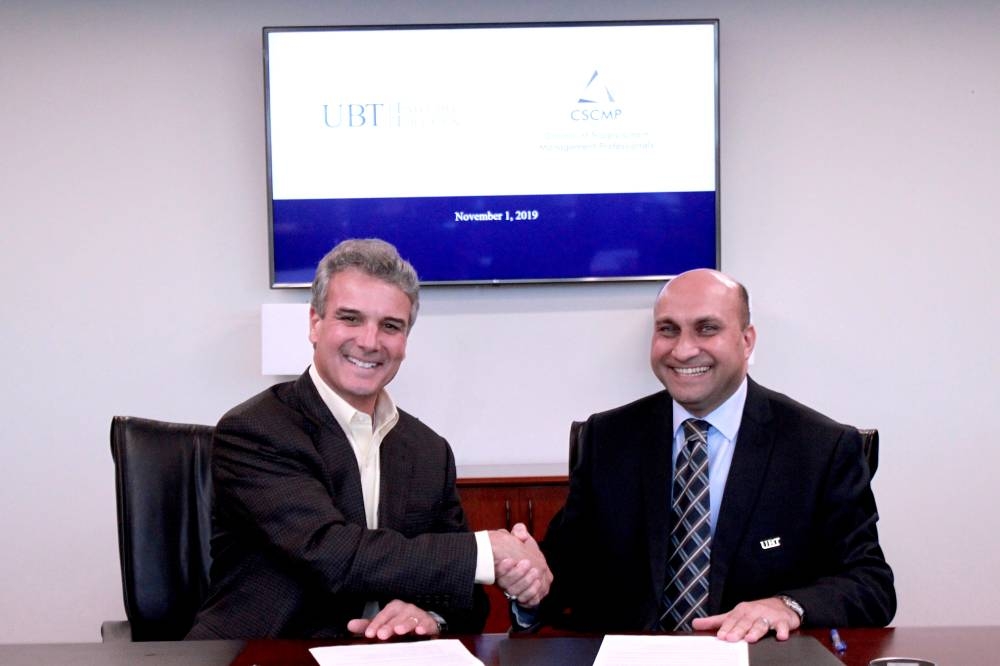 Amir Dhia, UBT Executive Education Director General, and  Rick Blasgen, CSCMP President and CEO, shake hands after the signing of agreement