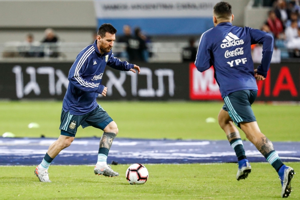 Argentina's forward Lionel Messi (L) dribbles a ball while warming up ahead of the friendly football match between Argentina and Uruguay at the Bloomfield stadium in the Israeli coastal city of Tel Aviv on Monday. — AFP