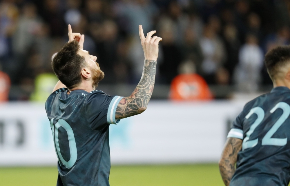 Argentina's forward Lionel Messi (L) dribbles a ball while warming up ahead of the friendly football match between Argentina and Uruguay at the Bloomfield stadium in the Israeli coastal city of Tel Aviv on Monday. — AFP