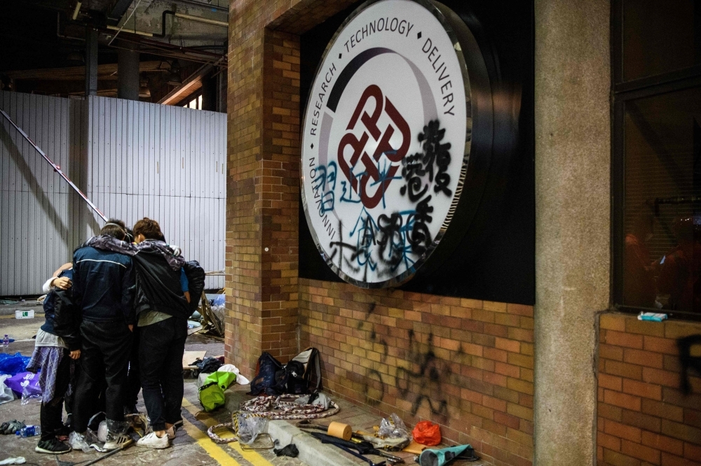 A protester crawls within a sewer tunnel to see how wide it is as he and others try to find an escape route from the Hong Kong Polytechnic University in the Hung Hom district of Hong Kong early morning on Tuesday. — AFP