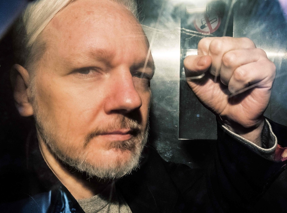 WikiLeaks founder Julian Assange gestures from the window of a prison van as he is driven into Southwark Crown Court in London in this May 1, 2019 file photo. — AFP