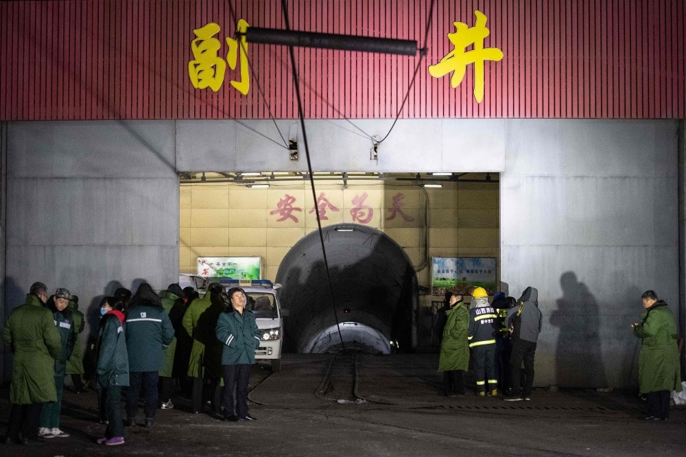 Rescuers carry a victim at the site of a coal mine explosion in Pingyao, in China's northern Shanxi province, early on Tuesday. — AFP