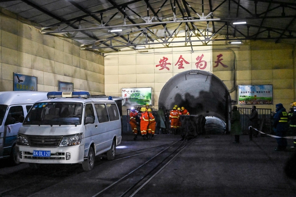 Rescuers carry a victim at the site of a coal mine explosion in Pingyao, in China's northern Shanxi province, early on Tuesday. — AFP