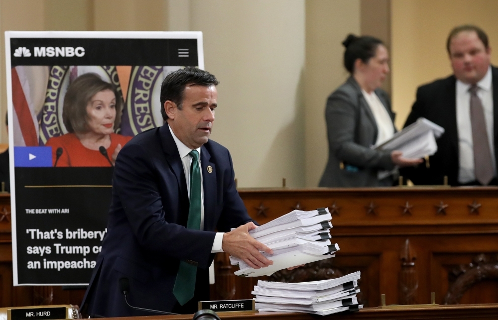Rep. John Ratcliffe places a stack of transcripts of depositons on the dais as Lt. Col. Alexander Vindman, National Security Council Director for European Affairs, and Jennifer Williams, adviser to Vice President Mike Pence for European and Russian affairs testify before the House Intelligence Committee in the Longworth House Office Building on Capitol Hill in Washington on Tuesday. — AFP