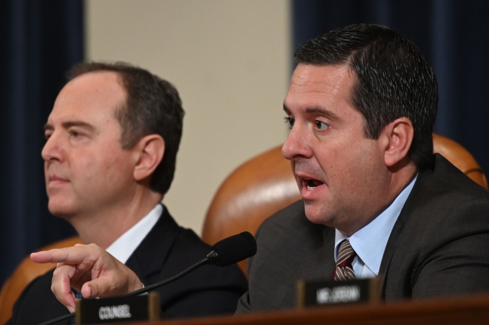 Rep. John Ratcliffe places a stack of transcripts of depositons on the dais as Lt. Col. Alexander Vindman, National Security Council Director for European Affairs, and Jennifer Williams, adviser to Vice President Mike Pence for European and Russian affairs testify before the House Intelligence Committee in the Longworth House Office Building on Capitol Hill in Washington on Tuesday. — AFP