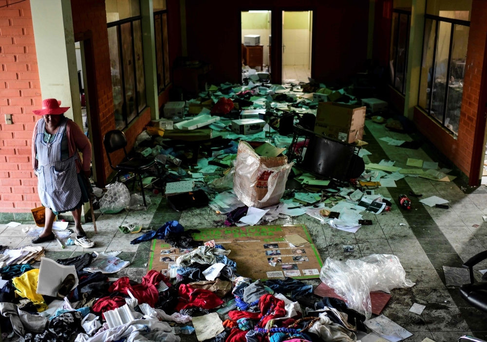 A woman stands looking inside a police station after it was looted, in Sacaba, Chapare province, Cochabamba, on Tuesday. -AFP