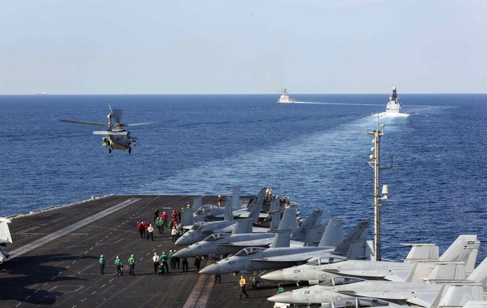 The aircraft carrier USS Abraham Lincoln, the air-defense destroyer HMS Defender and the guided-missile destroyer USS Farragut transit the Strait of Hormuz on Tuesday. -AFP