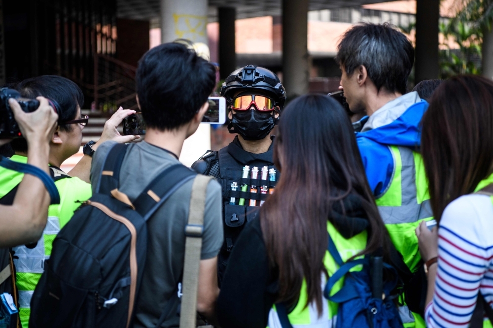 A male protester (C), who gave his age as 16, speaks to the media at the campus of the Hong Kong Polytechnic University in the Hung Hom district of Hong Kong on Wednesday. -AFP