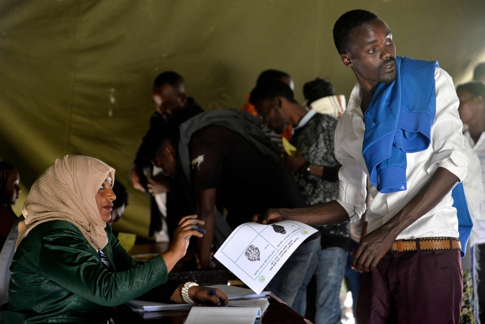 Voters pose for a picture with their identity documents while waiting in a queue to cast their vote during the Sidama referendum in Hawassa, Ethiopia, on Wednesday. — AFP