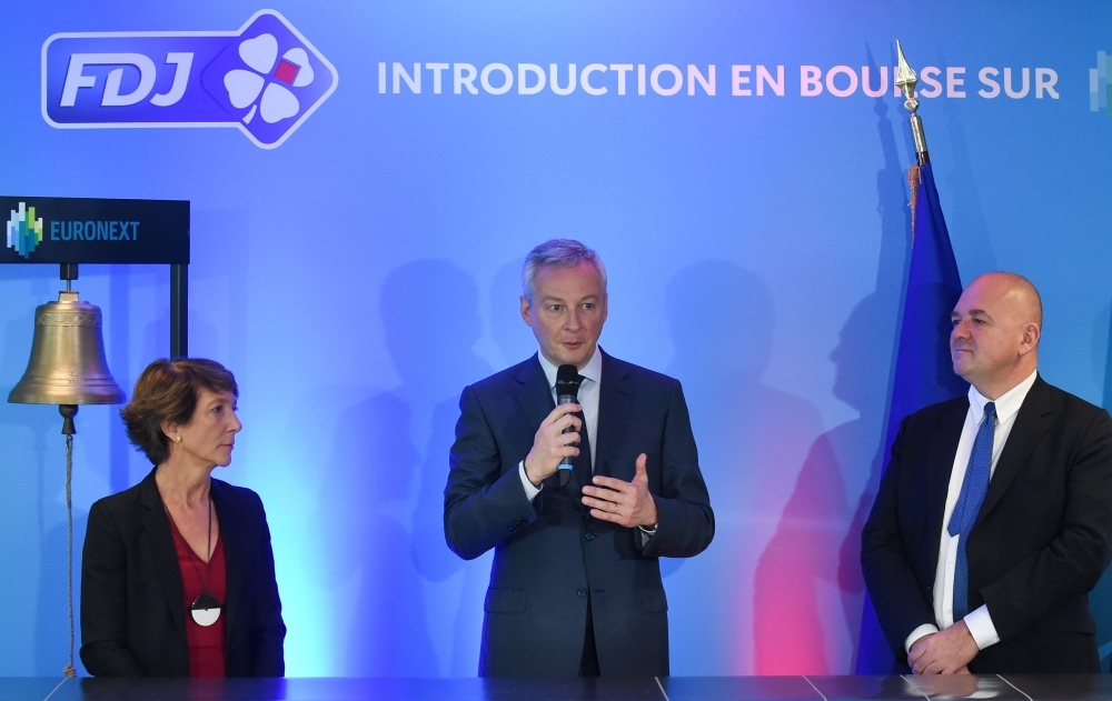 French Economy Minister Bruno Le Maire (C) speaks next to Francaise des Jeux head Stephane Pallez (L) and Euronext Group's Chairman and CEO Stephane Boujnah after the launch of the initial public offering of France's lottery Francaise des Jeux (FDJ) at the Paris Stock Exchange Euronext (Bourse) in Paris on Thursday. — AFP