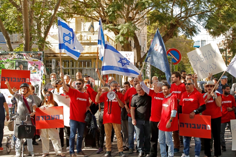 Supporters of Israel's Labour party chant slogans and hold flags and banners as they attend a rally against Israeli Prime Minister Benjamin Netanyahu outside the Likud party headquaters in the coastal Mediterranean city of Tel Aviv on Friday. — AFP