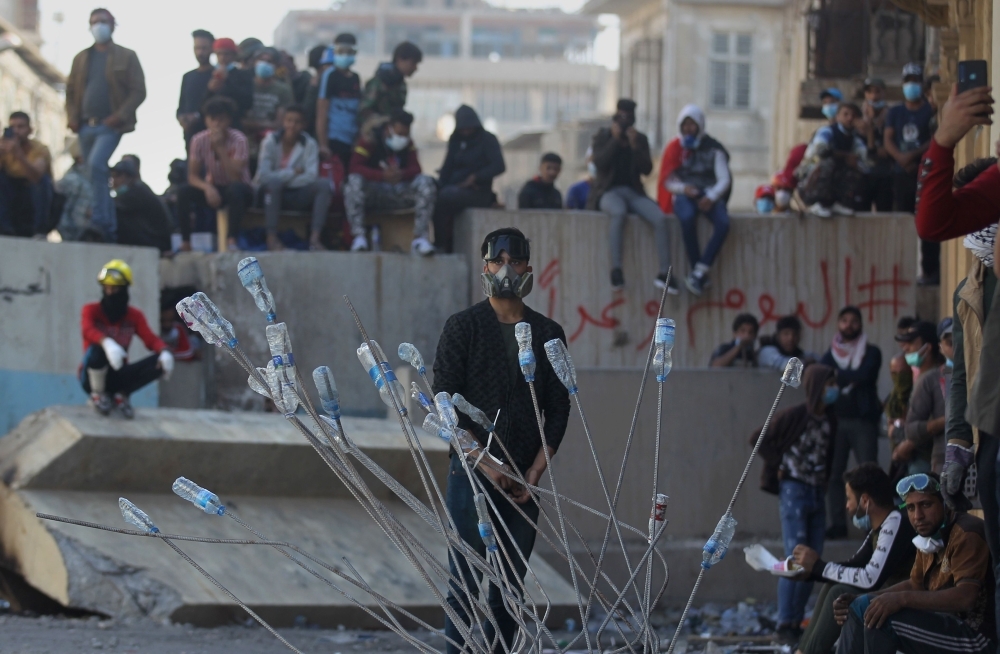 Iraqi anti-government protesters clash with security forces in Al-Rasheed street near Al-Ahrar bridge on Friday. — AFP