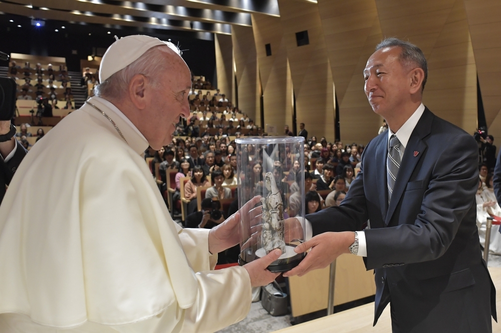 Pope receives flowers from women dressed in kimonos as he leaves Tokyo's Haneda airport on Tuesday. -AFP