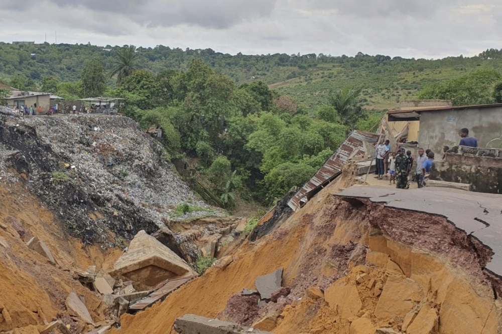 A road surface swept away by a landslide caused by torrential overnight rains is photographed in the Lemba district of Kinshasa on Tuesday. — AFP