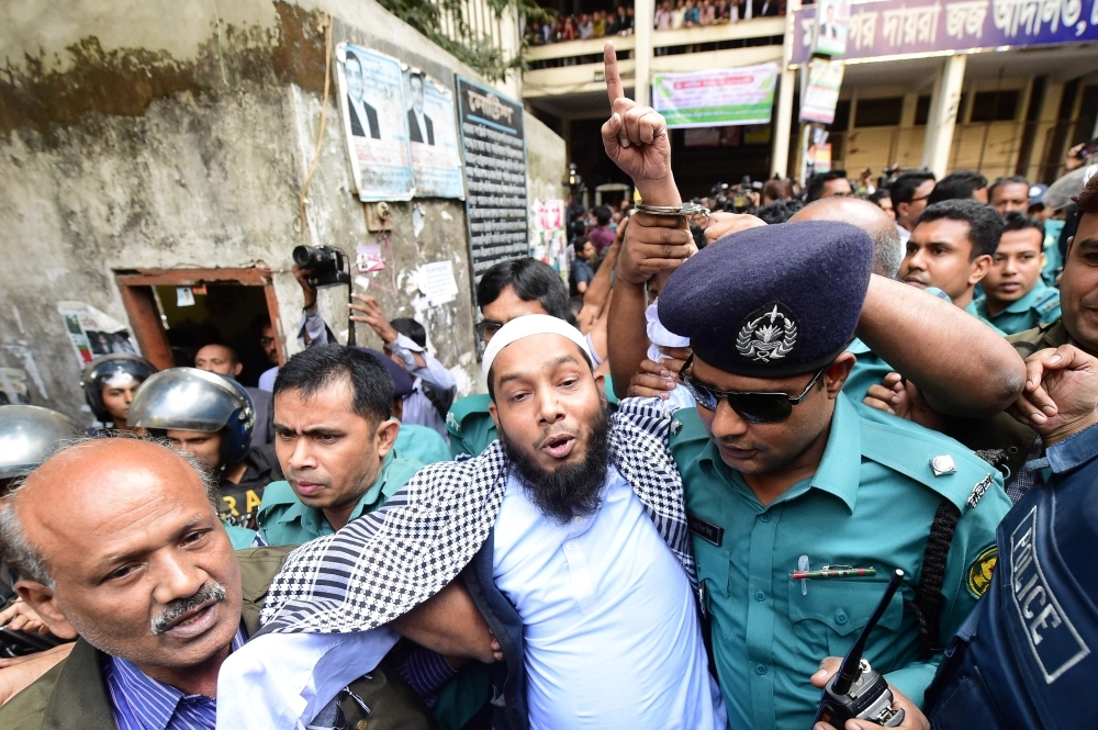 Police escort extremists, center, accused of allegedly plotting the Holey Artisan Bakery cafe attack, carried out by militants, to a courtroom for their trial in Dhaka on Wednesday. — AFP