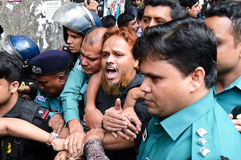 Police escort extremists, center, accused of allegedly plotting the Holey Artisan Bakery cafe attack, carried out by militants, to a courtroom for their trial in Dhaka on Wednesday. — AFP