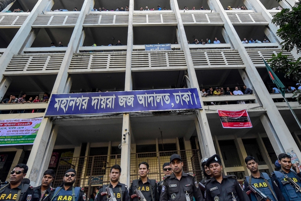 Police escort extremists, center, accused of allegedly plotting the Holey Artisan Bakery cafe attack, carried out by militants, to a courtroom for their trial in Dhaka on Wednesday. — AFP