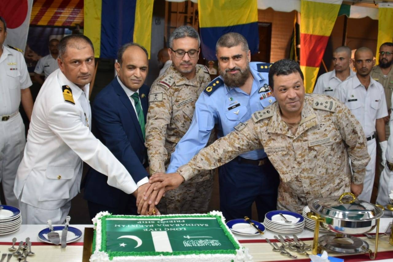 Saudi and Pakistani Naval officers, along with the consul general, commemorate the day by cutting a Pak-Saudi friendship cake.