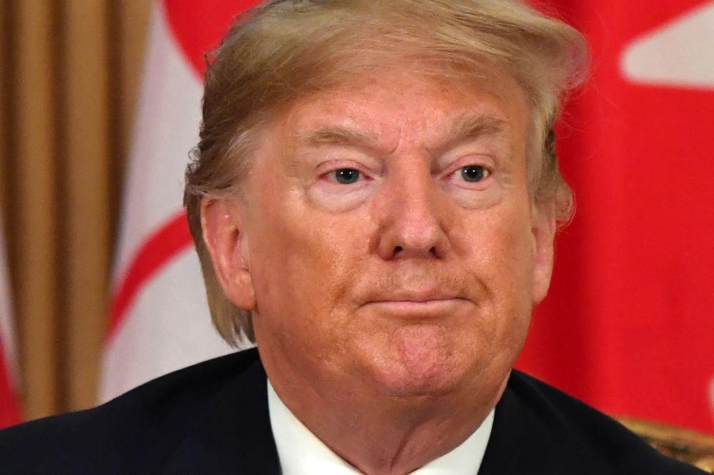 US President Donald Trump speaks with Canada's Prime Minister Justin Trudeau, not seen, during a meeting at Winfield House, London, on Tuesday. — AFP