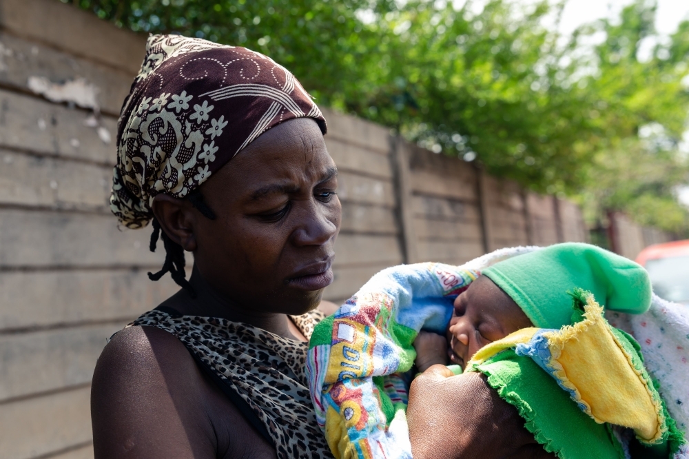 Sixty-nine-year-old Esther Gwena, an untrained midwife  adjusts a pair of surgical gloves as she prepares herself for a long day ahead at her two-room apartment in Mbare high-density suburb in Harare, on November 21, 2019. -AFP