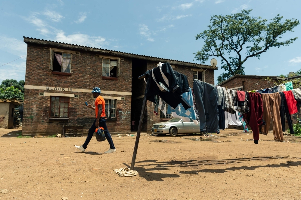 Sixty-nine-year-old Esther Gwena, an untrained midwife  adjusts a pair of surgical gloves as she prepares herself for a long day ahead at her two-room apartment in Mbare high-density suburb in Harare, on November 21, 2019. -AFP