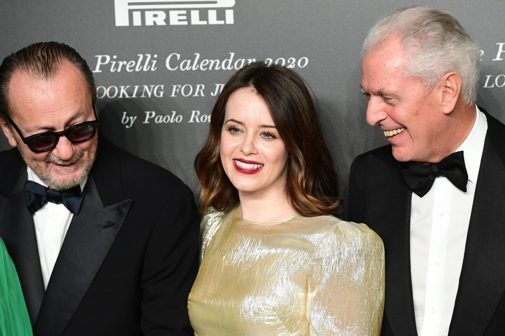 Italian photographer Paolo Roversi, left, and British actress Claire Foy, center, and Pirelli's CEO Marco Tronchetti Provera attend the presentation of the Pirelli 2020 Calendar 