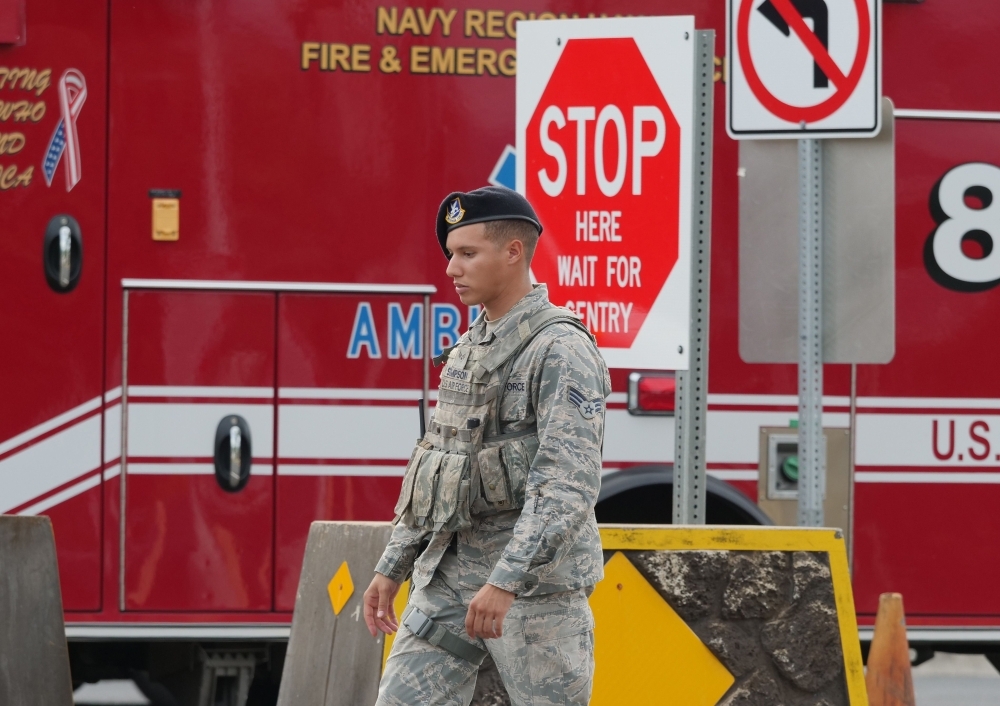 A security guard walks past a naval emergency ambulance responding to a fatal shooting at the Pearl Harbor Naval Shipyard, on Oahu, Hawaii, on Wednesday. — AFP