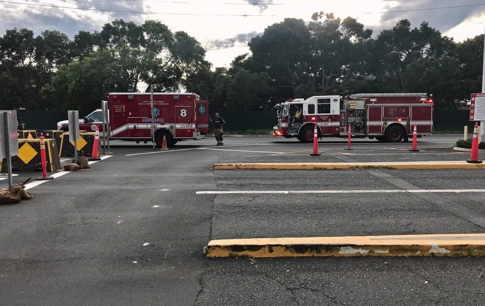 A security guard walks past a naval emergency ambulance responding to a fatal shooting at the Pearl Harbor Naval Shipyard, on Oahu, Hawaii, on Wednesday. — AFP