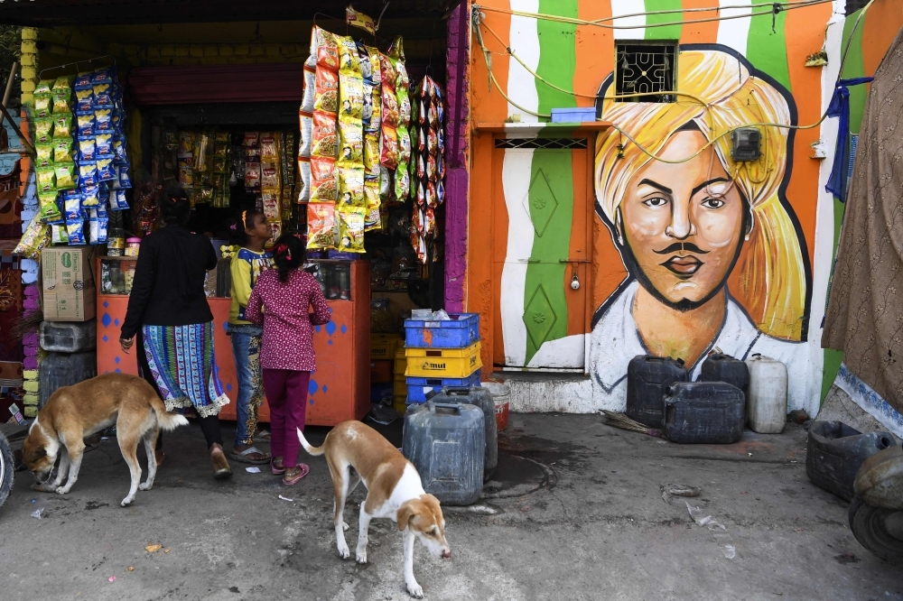 Local residents shop from a store next to a home adorned with a mural painted by artists from 'Delhi Street Art' group at the Raghubir Nagar slum in New Delhi in this Dec. 2, 2019 file photo. — AFP