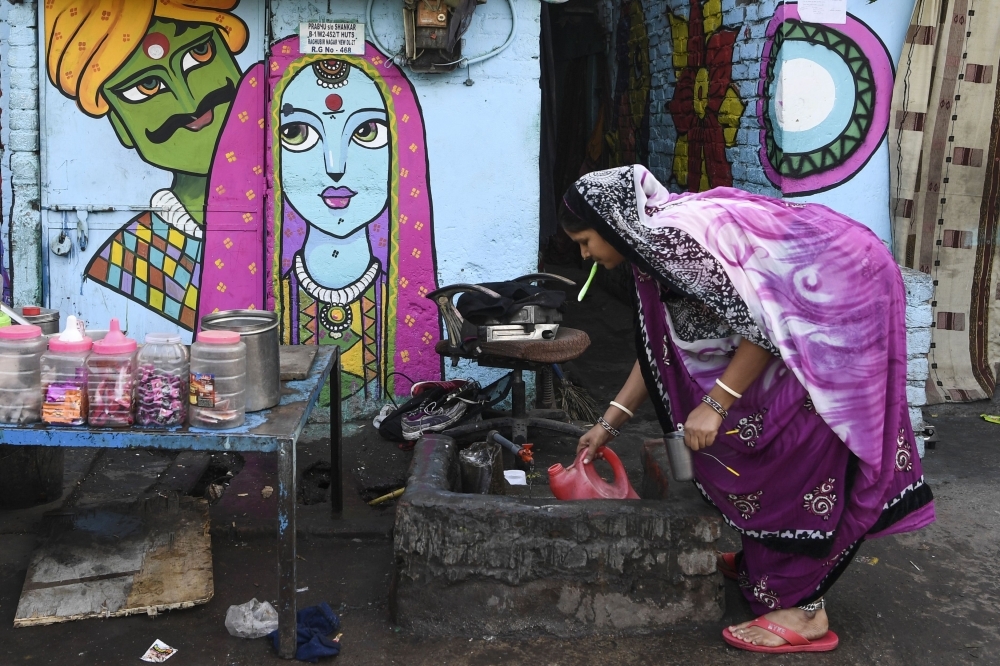 Local residents shop from a store next to a home adorned with a mural painted by artists from 'Delhi Street Art' group at the Raghubir Nagar slum in New Delhi in this Dec. 2, 2019 file photo. — AFP